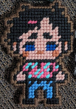 A yarn figure of Tim Stoker from the horror podcast The Magnus Archives