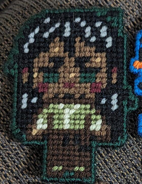 A yarn figure of Jonathan Sims, the Archivist, from the horror podcast The Magnus Archives